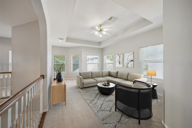 living room with baseboards, visible vents, a ceiling fan, carpet floors, and a raised ceiling