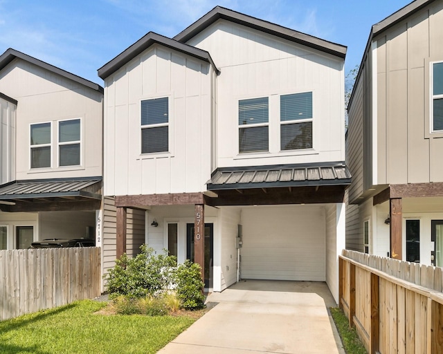 multi unit property featuring a standing seam roof, fence, metal roof, and driveway