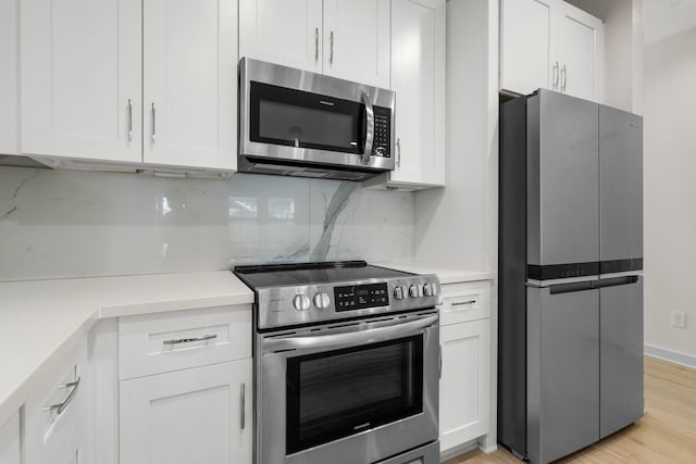 kitchen with backsplash, white cabinetry, and appliances with stainless steel finishes