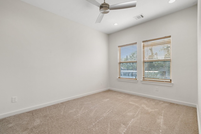 unfurnished room with a ceiling fan, baseboards, visible vents, and light carpet
