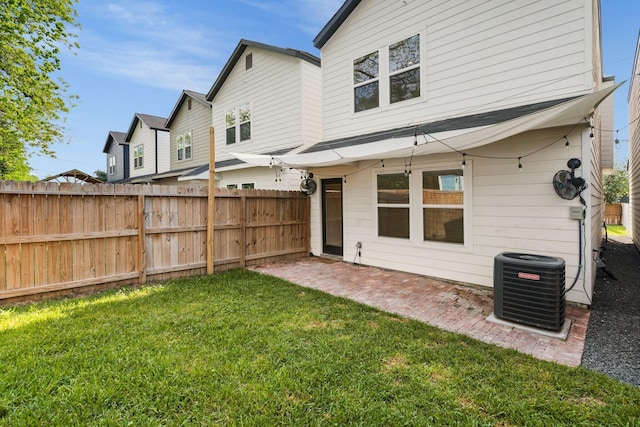rear view of house featuring central air condition unit, a lawn, fence, and a patio area
