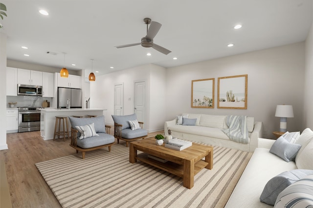 living area with recessed lighting, a ceiling fan, visible vents, and light wood-style flooring