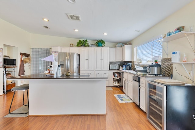 12802 Bermuda Beach Dr, Galveston, TX 77554 - kitchen with stainless steel appliances, tasteful backsplash, white cabinets, a kitchen island, and recessed lighting