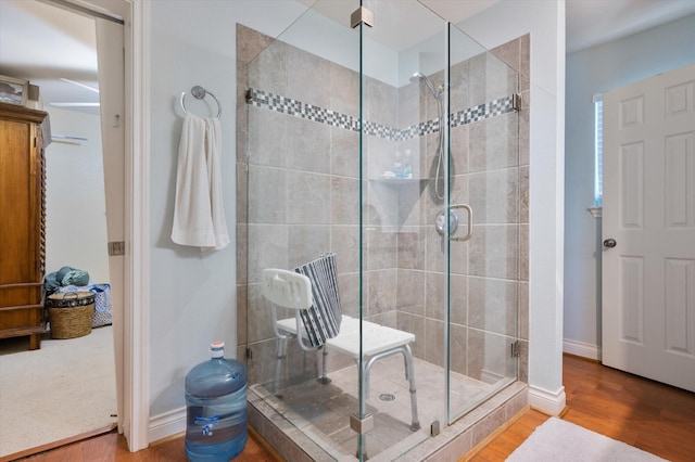 12802 Bermuda Beach Dr, Galveston, TX 77554 - bathroom with a stall shower, wood finished floors, and baseboards