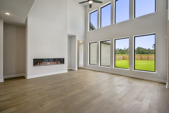 9618 Leafgate Ct, Missouri City, TX 77459 - unfurnished living room with healthy amount of natural light, ceiling fan, baseboards, a towering ceiling, and recessed lighting