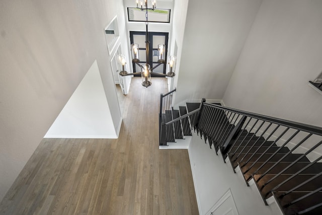 9618 Leafgate Ct, Missouri City, TX 77459 - staircase with a chandelier, wood finished floors, a towering ceiling, and baseboards