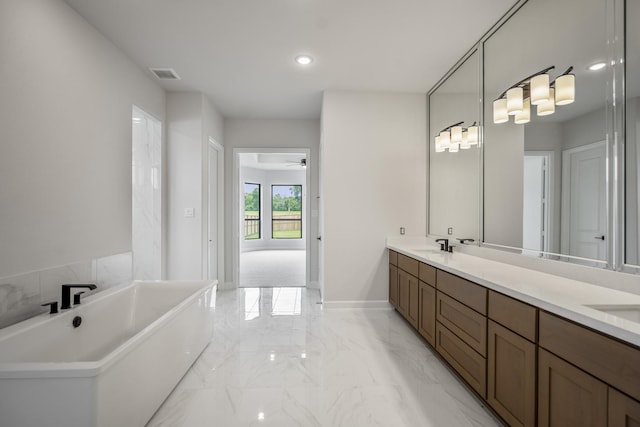 9618 Leafgate Ct, Missouri City, TX 77459 - bathroom with marble tiled floors, a soaking tub, double vanity, recessed lighting, and a ceiling fan