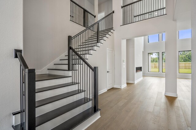 9618 Leafgate Ct, Missouri City, TX 77459 - stairway with a high ceiling, wood finished floors, baseboards, and a warm lit fireplace