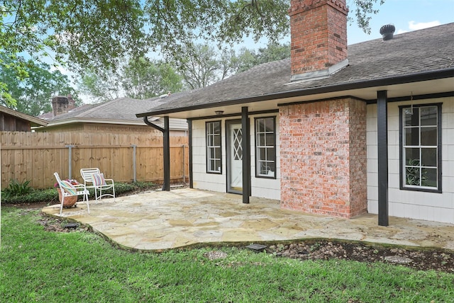 3309 Knob Hill St, Deer Park, TX 77536 - rear view of house featuring a patio, a chimney, a shingled roof, and fence