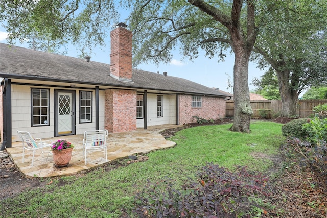 3309 Knob Hill St, Deer Park, TX 77536 - rear view of house featuring a chimney, a patio area, a lawn, fence, and brick siding