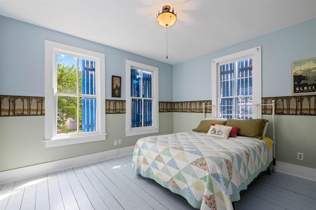 bedroom featuring baseboards and hardwood / wood-style flooring