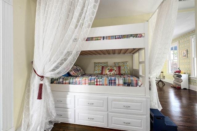 bedroom featuring dark wood-type flooring, baseboards, and wallpapered walls