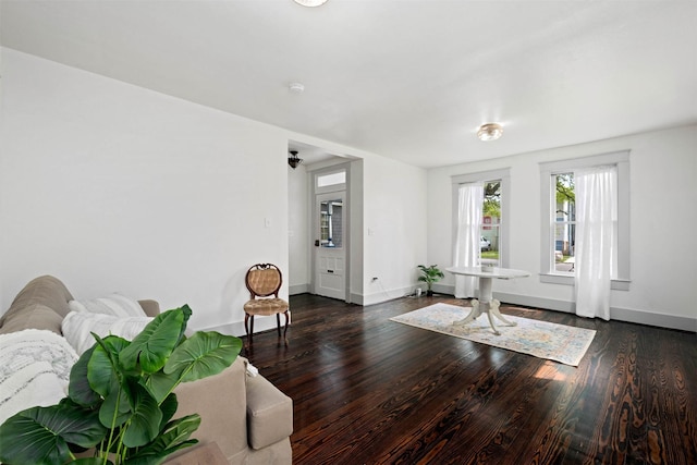 living area with baseboards and wood finished floors