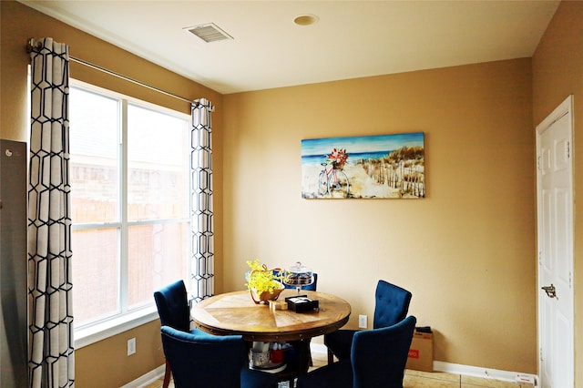 dining room featuring plenty of natural light, visible vents, and baseboards