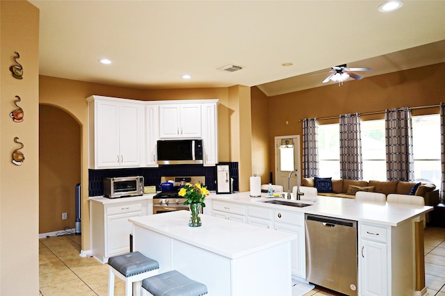 kitchen with a peninsula, a ceiling fan, visible vents, appliances with stainless steel finishes, and a sink