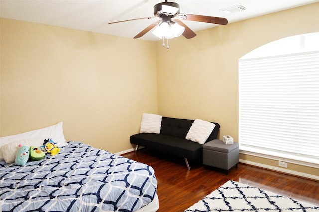bedroom with wood finished floors, ceiling fan, baseboards, and visible vents