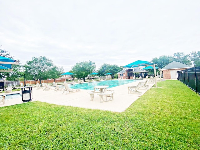 community pool featuring a patio, fence, and a lawn