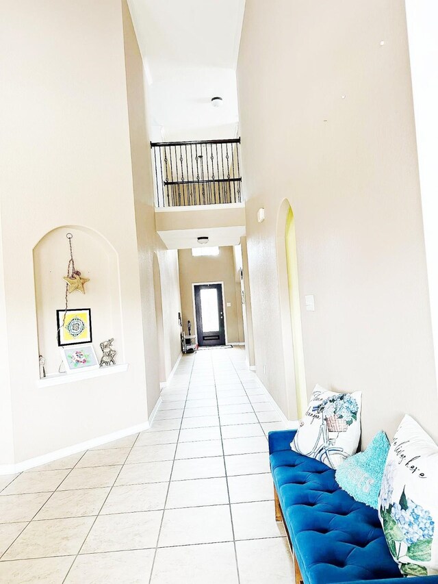 24423 Hampton Lakes Dr, Katy, TX 77493 - corridor featuring tile patterned floors, a towering ceiling, arched walkways, and baseboards
