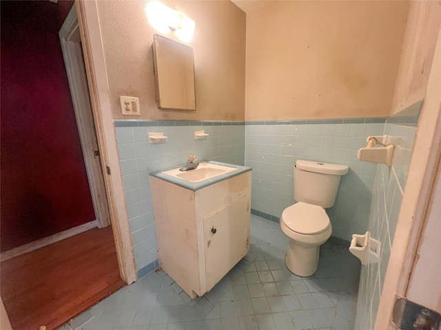 105 Longridge Dr, La Marque, TX 77568 - half bath featuring vanity, tile patterned flooring, a wainscoted wall, toilet, and tile walls