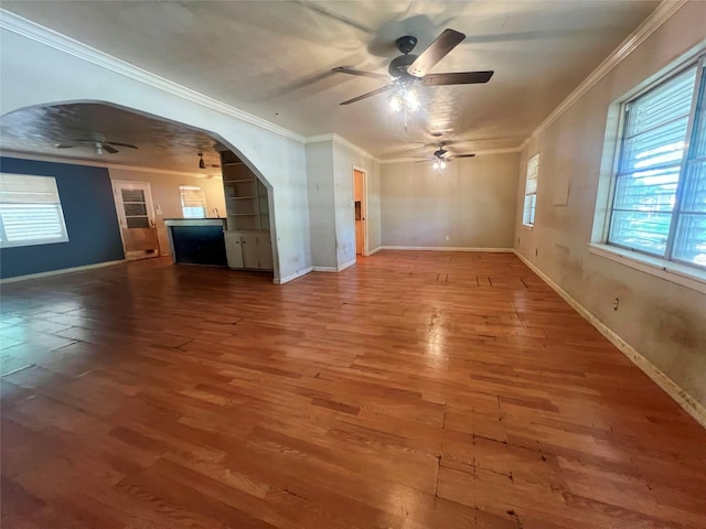 105 Longridge Dr, La Marque, TX 77568 - unfurnished living room with arched walkways, a ceiling fan, crown molding, and wood finished floors