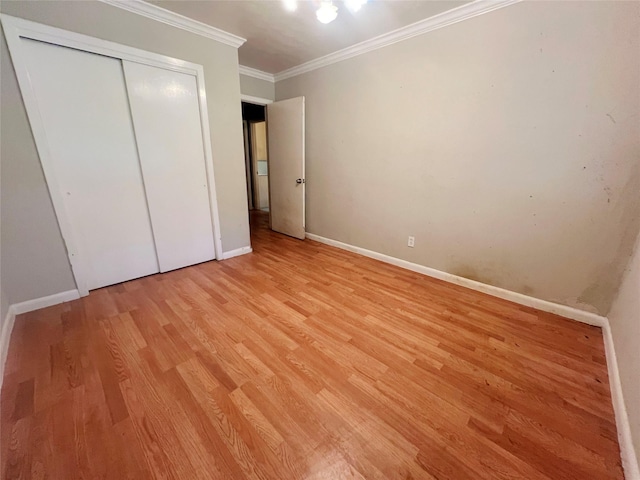 105 Longridge Dr, La Marque, TX 77568 - unfurnished bedroom featuring crown molding, a closet, light wood-style flooring, and baseboards
