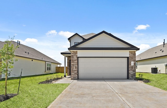 view of front of home featuring a front lawn, central air condition unit, concrete driveway, and brick siding