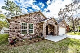 view of front of property featuring a front yard, a garage, and driveway