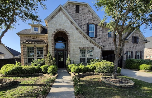 7106 Prairie Grass Ln, Katy, TX 77493 - french country inspired facade with brick siding, concrete driveway, stone siding, and a garage