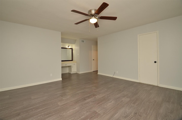 empty room featuring visible vents, ceiling fan, baseboards, and dark wood-style floors
