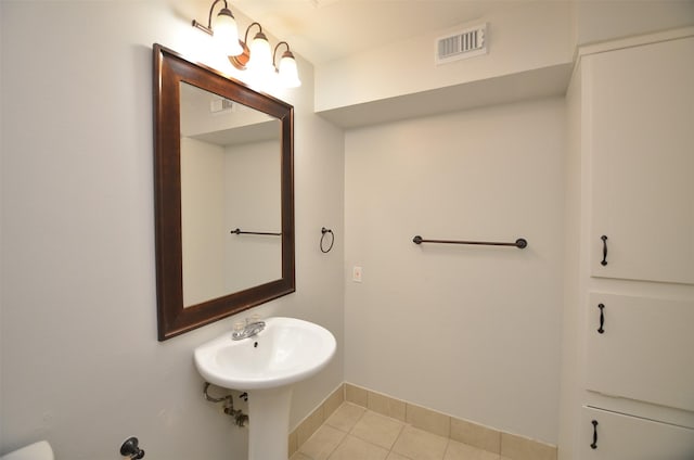 bathroom with a sink, baseboards, tile patterned flooring, and visible vents