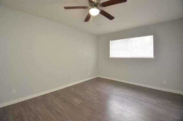 empty room featuring baseboards, a ceiling fan, and dark wood-style floors