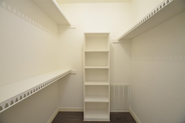 spacious closet with dark wood-type flooring and visible vents
