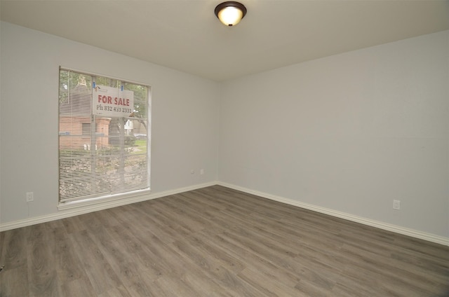 empty room featuring baseboards and wood finished floors