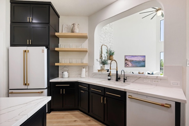 26719 Outback Dr, Katy, TX 77493 - kitchen featuring light stone countertops, white appliances, a sink, and dark cabinetry