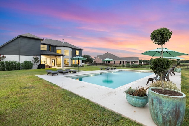 26719 Outback Dr, Katy, TX 77493 - pool at dusk featuring a yard, fence, a fenced in pool, and a patio