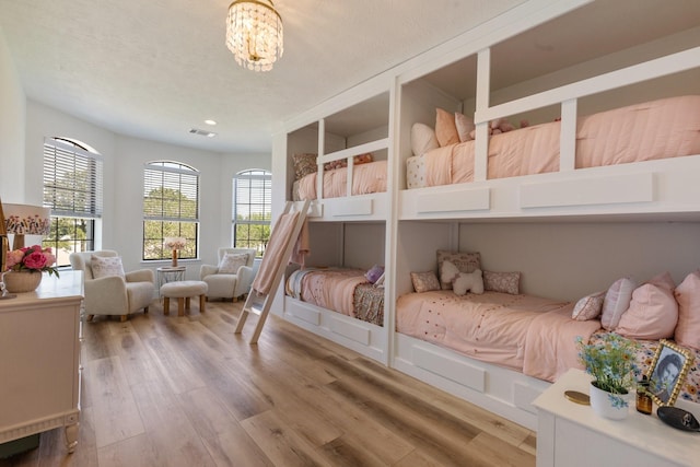 26719 Outback Dr, Katy, TX 77493 - bedroom with light wood-type flooring, an inviting chandelier, a textured ceiling, and recessed lighting