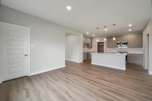 1014 Wildflower Way Dr, Beasley, TX 77417 - kitchen with stainless steel stove, a sink, range hood, backsplash, and light wood-type flooring