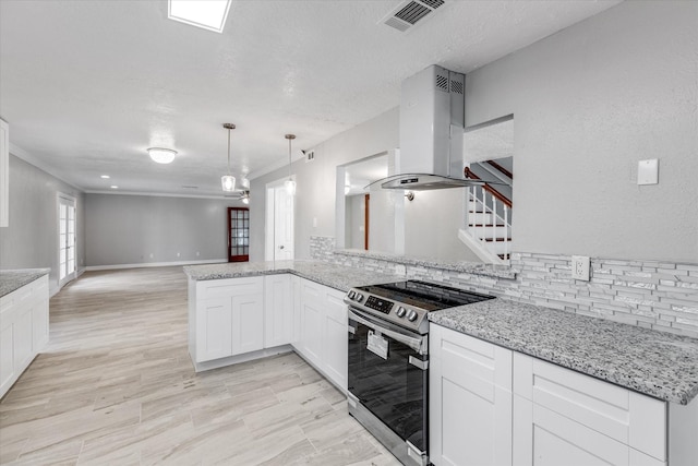 kitchen featuring stainless steel electric range oven, visible vents, light stone counters, island range hood, and open floor plan