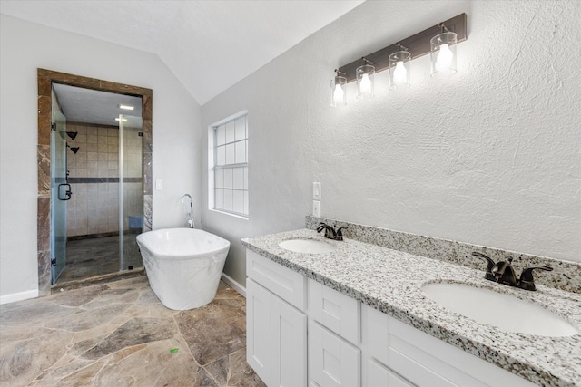 bathroom with a soaking tub, a stall shower, stone finish floor, and a sink