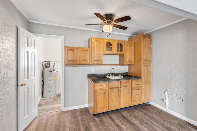 kitchen featuring dark wood-style floors, a sink, ceiling fan, water heater, and dark countertops