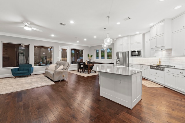 6931 Harvest Ln, Katy, TX 77493 - kitchen with open floor plan, backsplash, crown molding, visible vents, and stainless steel appliances