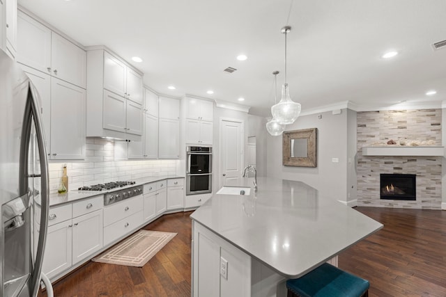 6931 Harvest Ln, Katy, TX 77493 - kitchen featuring a sink, ornamental molding, appliances with stainless steel finishes, dark wood finished floors, and backsplash