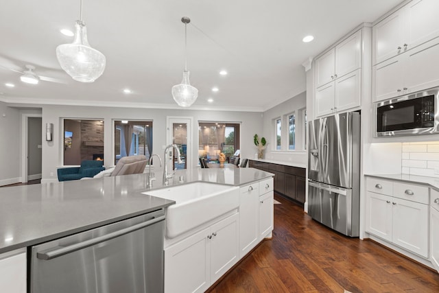 6931 Harvest Ln, Katy, TX 77493 - kitchen with a sink, open floor plan, appliances with stainless steel finishes, dark wood finished floors, and crown molding