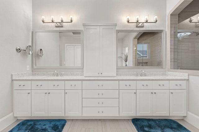 6931 Harvest Ln, Katy, TX 77493 - bathroom with tiled shower, double vanity, a sink, and baseboards