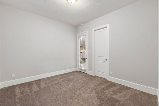 6931 Harvest Ln, Katy, TX 77493 - empty room with baseboards, carpet flooring, and a textured ceiling