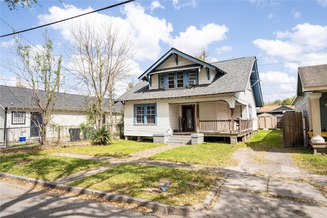 6503 Ave C, Houston, TX 77011 - bungalow-style house with a gate, a front lawn, a porch, fence, and a shingled roof