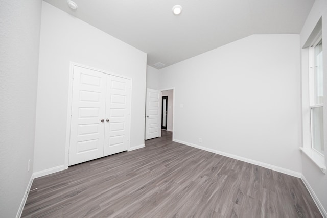 3001 Plains Cir, Brookshire, TX 77423 - unfurnished bedroom featuring wood finished floors, baseboards, a closet, and lofted ceiling