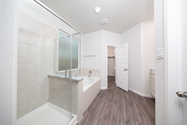 3001 Plains Cir, Brookshire, TX 77423 - full bath featuring a shower stall, a spacious closet, a garden tub, wood finished floors, and baseboards