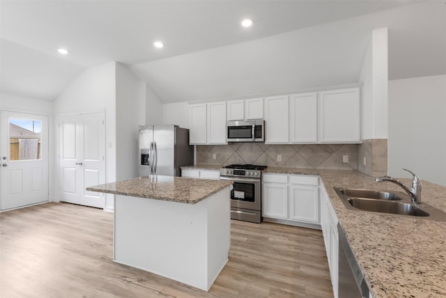 3319 Meadknoll Ln, Richmond, TX 77406 - kitchen featuring appliances with stainless steel finishes, a sink, lofted ceiling, white cabinets, and recessed lighting