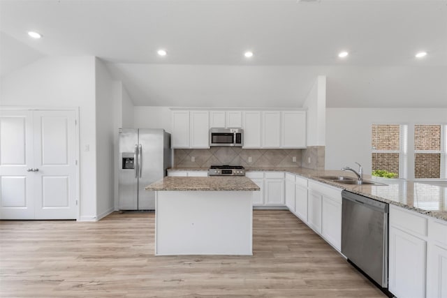 3319 Meadknoll Ln, Richmond, TX 77406 - kitchen featuring appliances with stainless steel finishes, lofted ceiling, a sink, decorative backsplash, and a center island